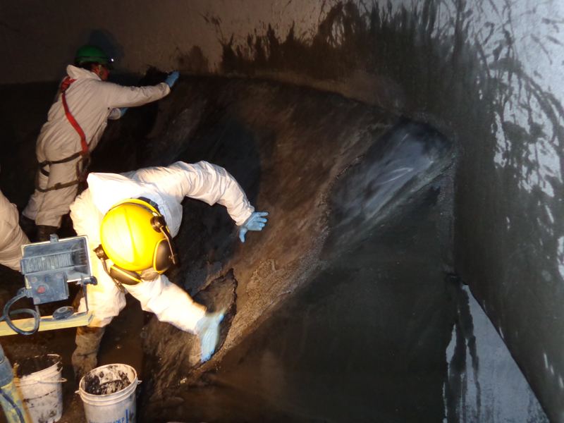 Técnico aplicando cerámica protectora en zona de descarga industrial